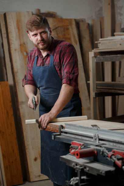 The master carpenter works with the tree in the workshop. Small business تركيب شواحن السيارات في أبوظبي