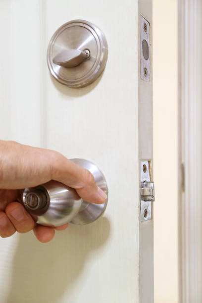 Hand holding steel doorknob for closing the door تركيب شواحن السيارات في أبوظبي